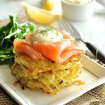 Smoked Salmon Potato Rosti Stack with a rocket salad and lemon wedges on the side