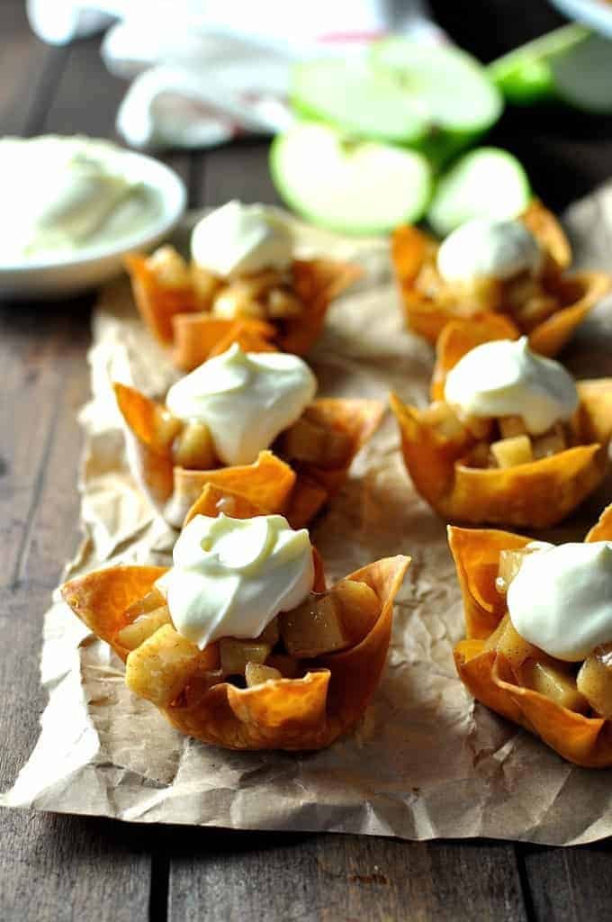 Six Mini Apple Pies made with wonton cups with a dollop of cream.