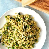Pea, Zucchini and Pesto Orzo / Risoni on a white plate with parmesan on the side.