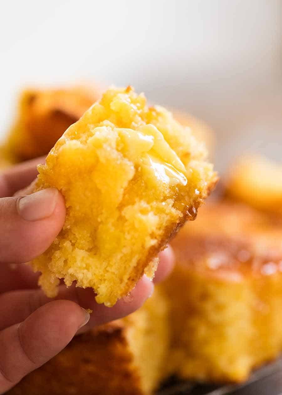 Hand holding piece of Cornbread, showing the inside of Cornbread
