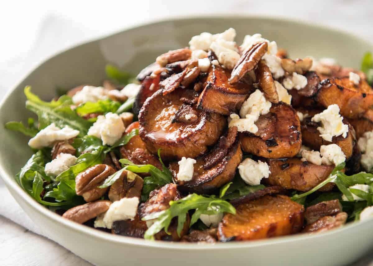 Roasted Sweet Potato Salad with arugula/rocket, pecans, goats cheese or feta, a sprinkle of bacon drizzled with a maple salad dressing.