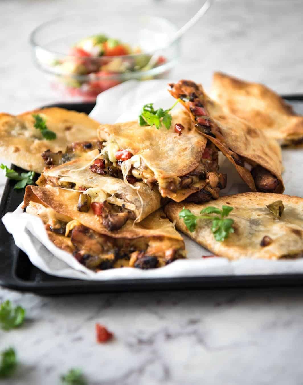 Crispy Oven Baked Chicken Quesadillas - This is how to make multiple Quesadillas at the same time! Crispy on the outside, stuffed with Mexican seasoned chicken and capsicum / bell peppers (and cheese of course!) www.recipetineats.com