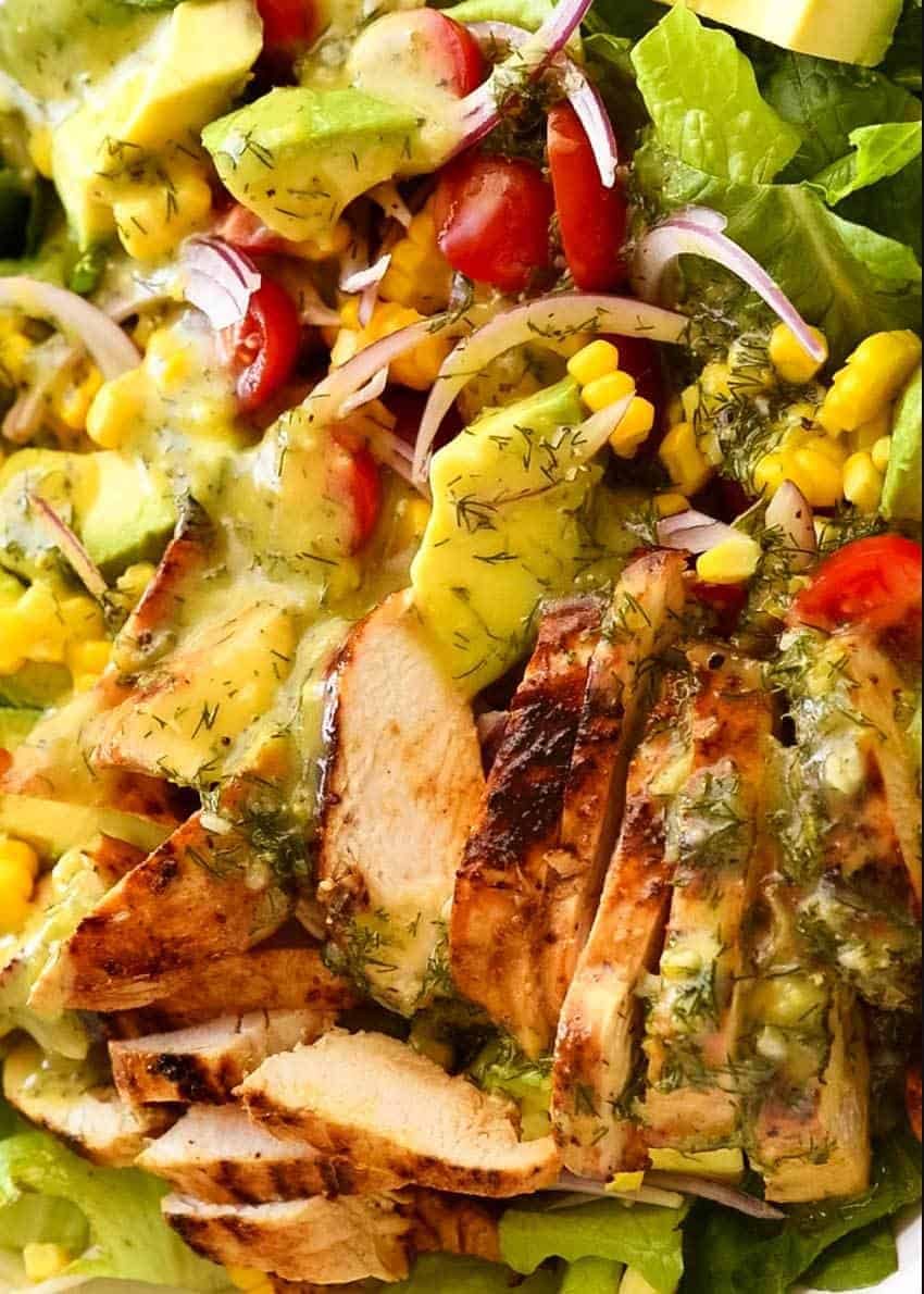 Close up of Lemon Chicken Salad with avocado, tomatoes and corn with lemon dill dressing.