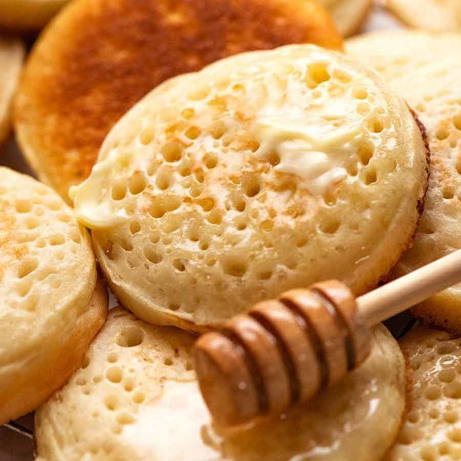 Close up of homemade crumpets with honey and butter