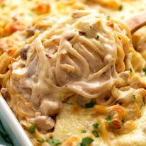 Close up of spoon lifting out some creamy Chicken Tetrazzini fresh out of the oven