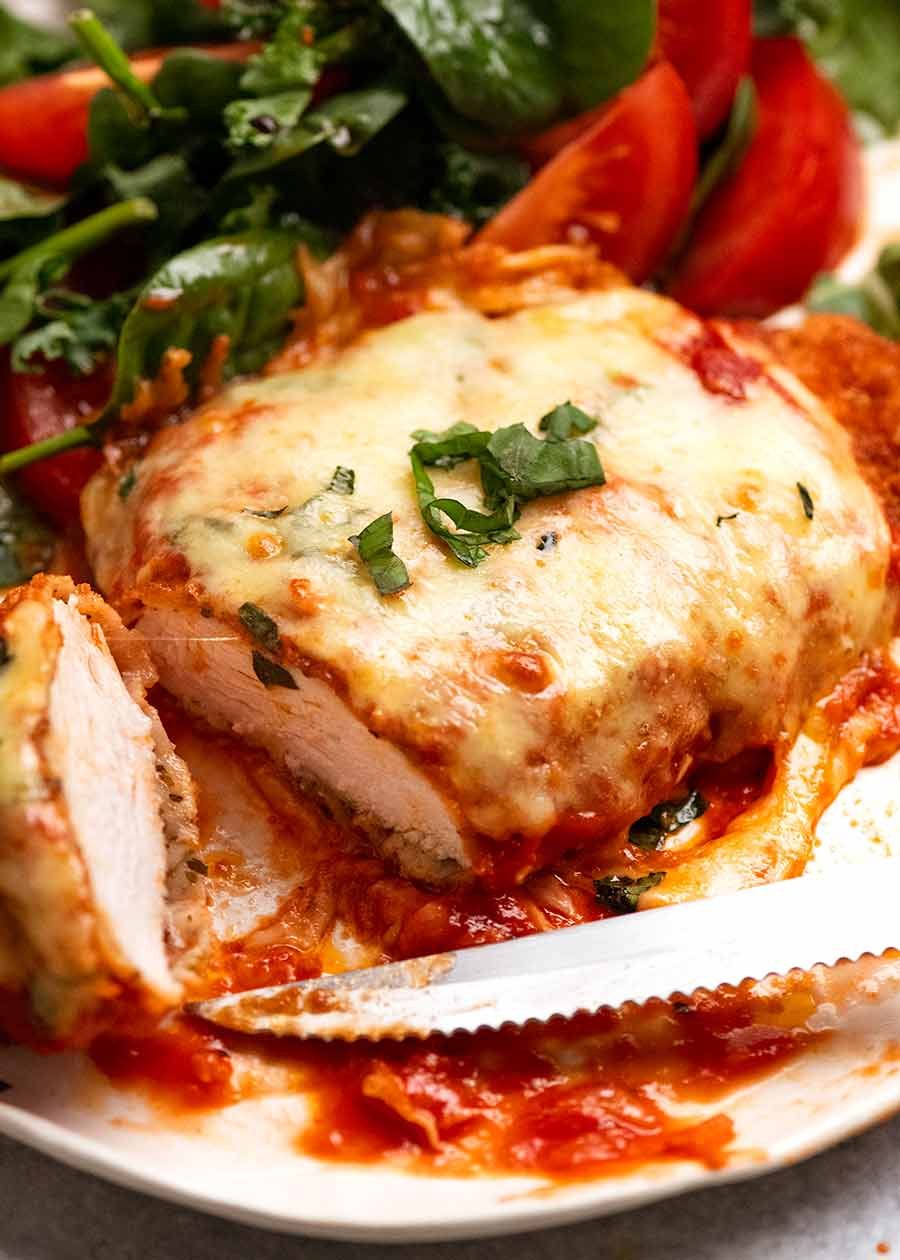 Close up of Chicken Parmigiana (Chicken Parmesan) with a garden side salad